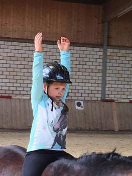 Kind bei ZENbo Balance Übung auf dem Pferd