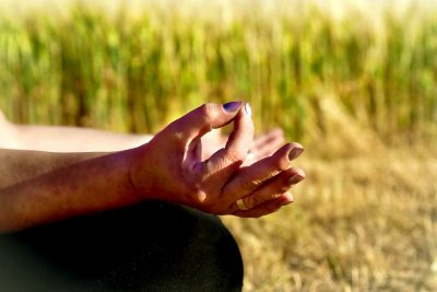 Seelenstärke Meditation mit Chin Mudra auf Wiese